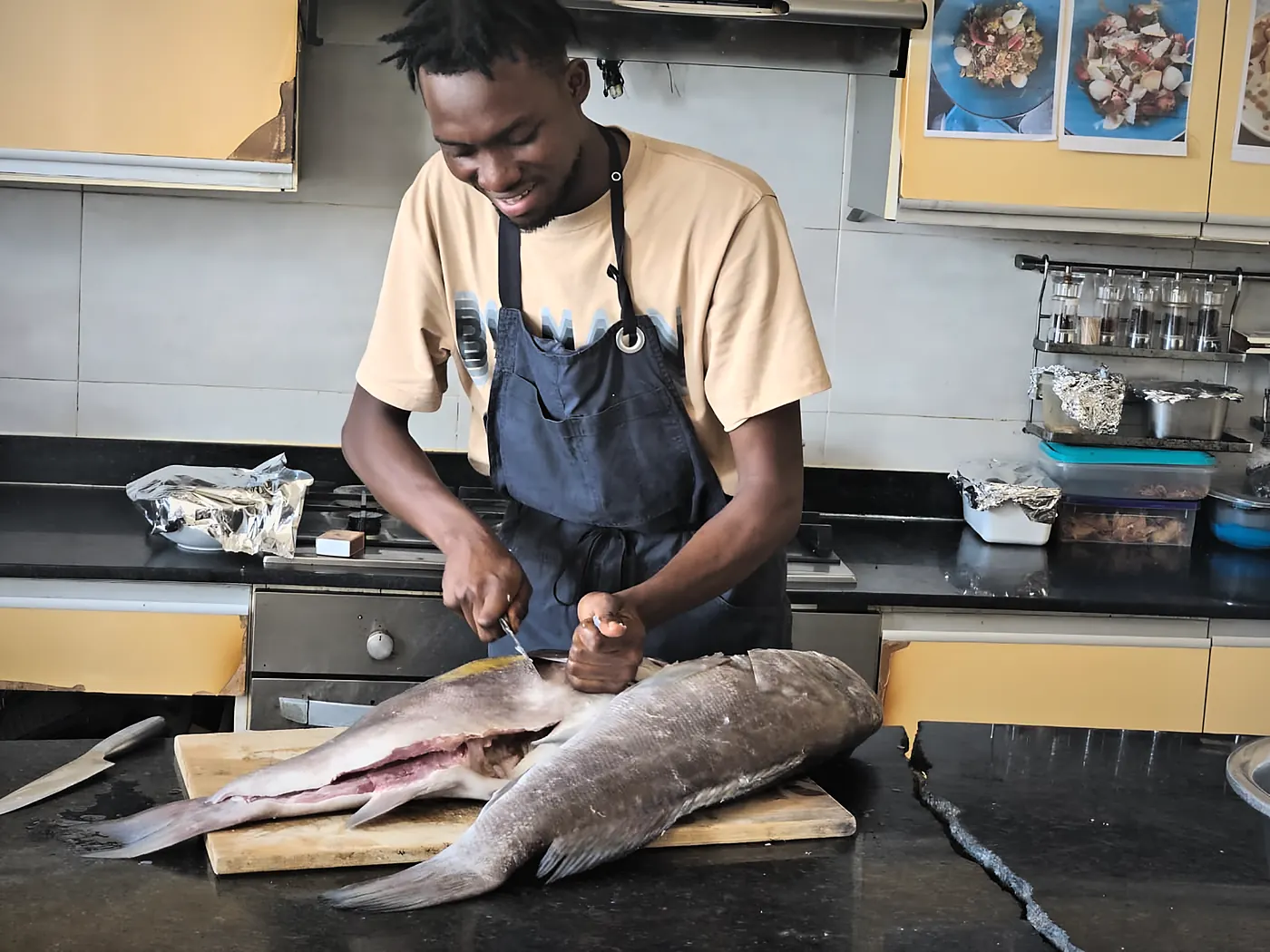 En cuisine, un cuisinier lève les filets d'un poisson