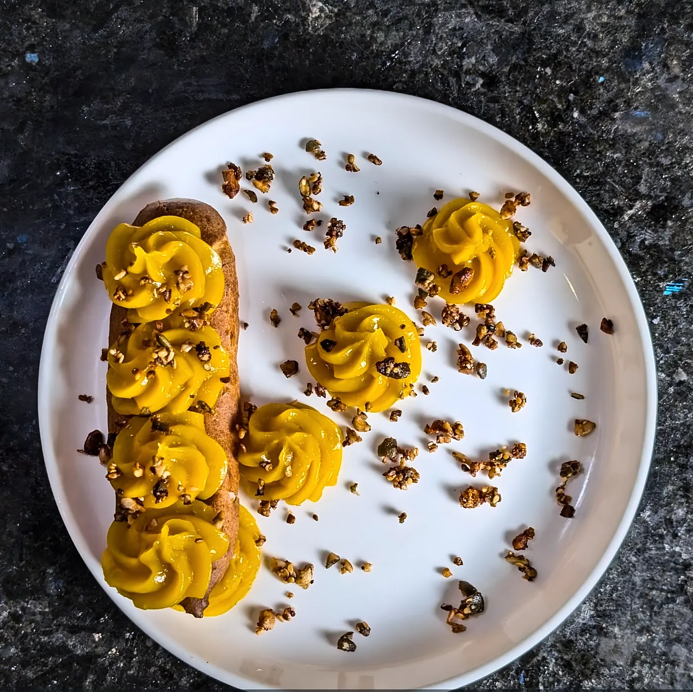Éclair garni de crémeux à la mangue et de croustillant