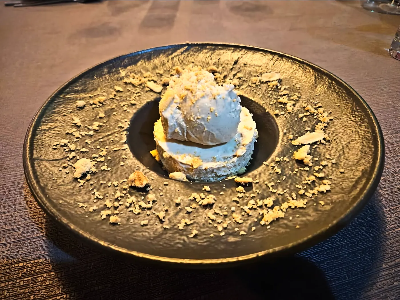Mousse et crumble sur une assiette en grès noir