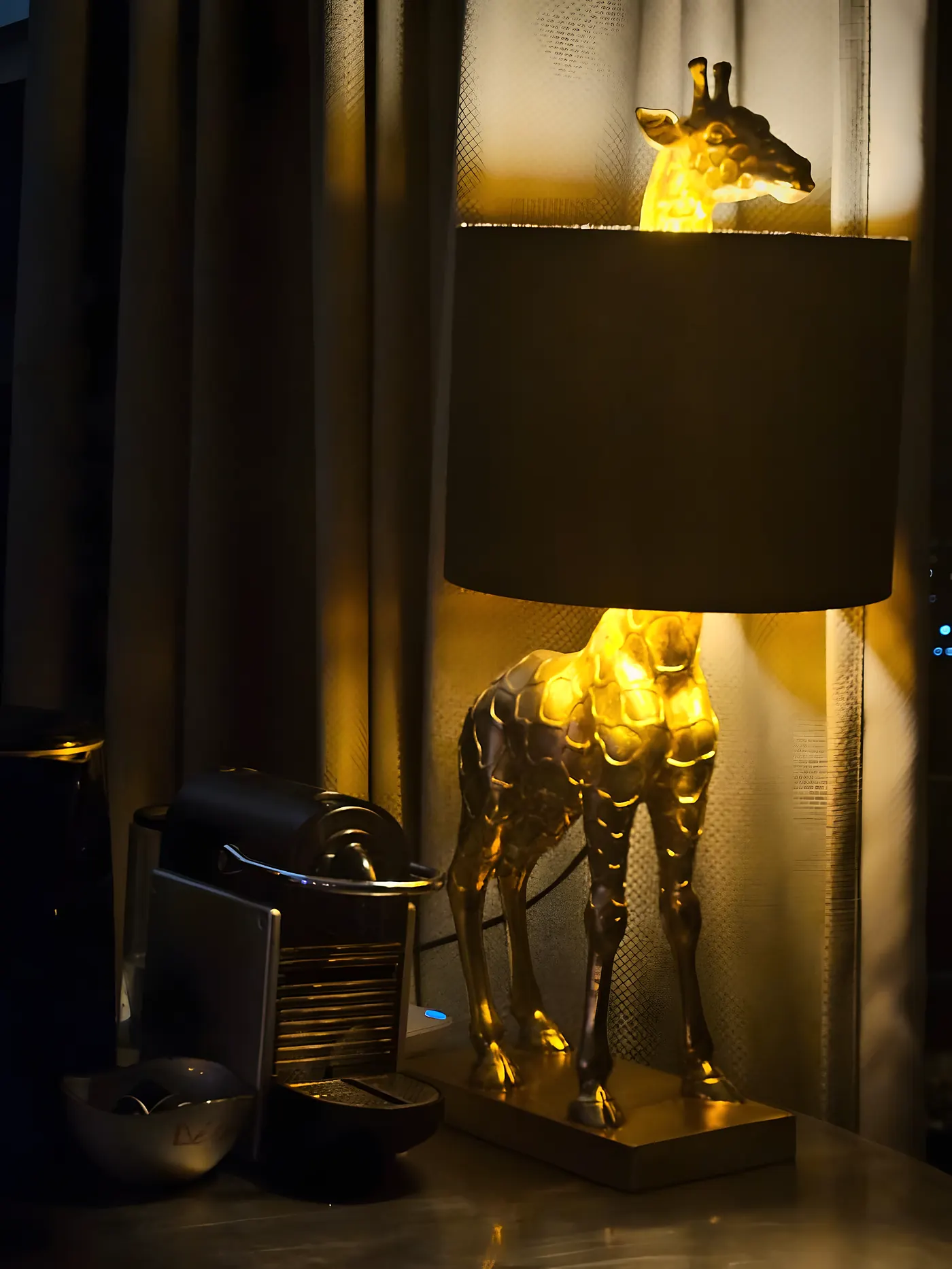 La lampe girafe dorée, éclairée dans la pénombre du salon