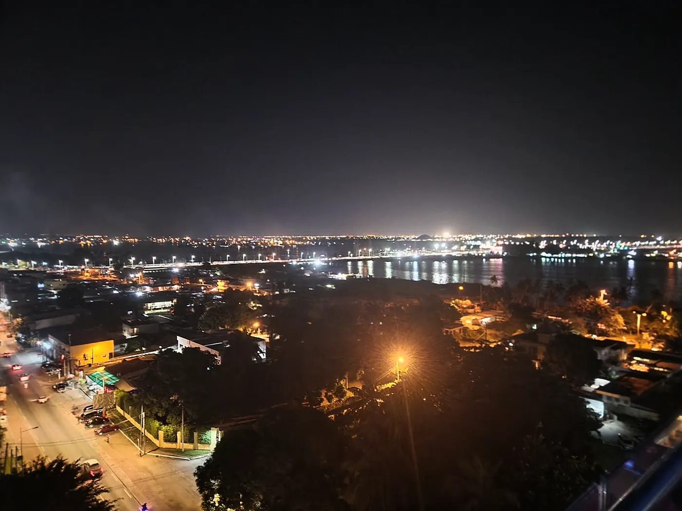 Panorama nocturne sur Abidjan et la lagune depuis le toit