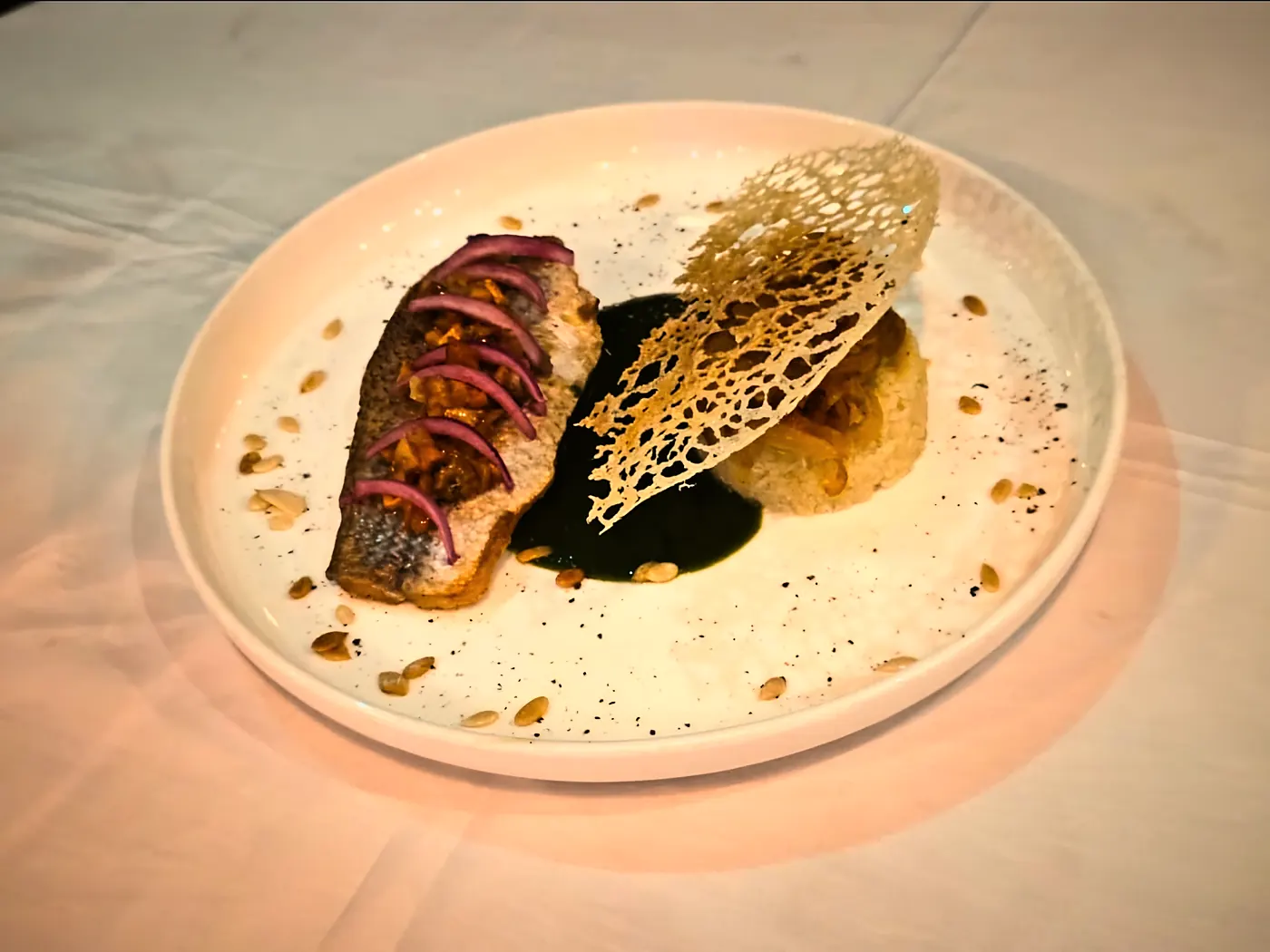 Filet de poisson aux pickles d'oignon rouge, sauce verte et tuile croustillante