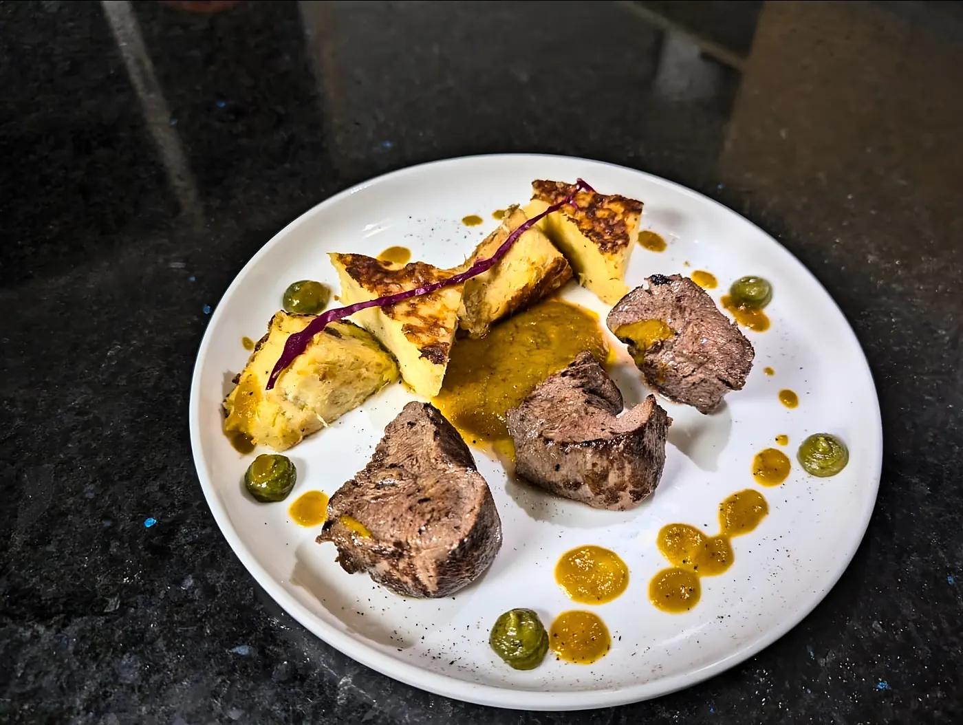 Médaillons de viande, gratin doré et points de sauce
