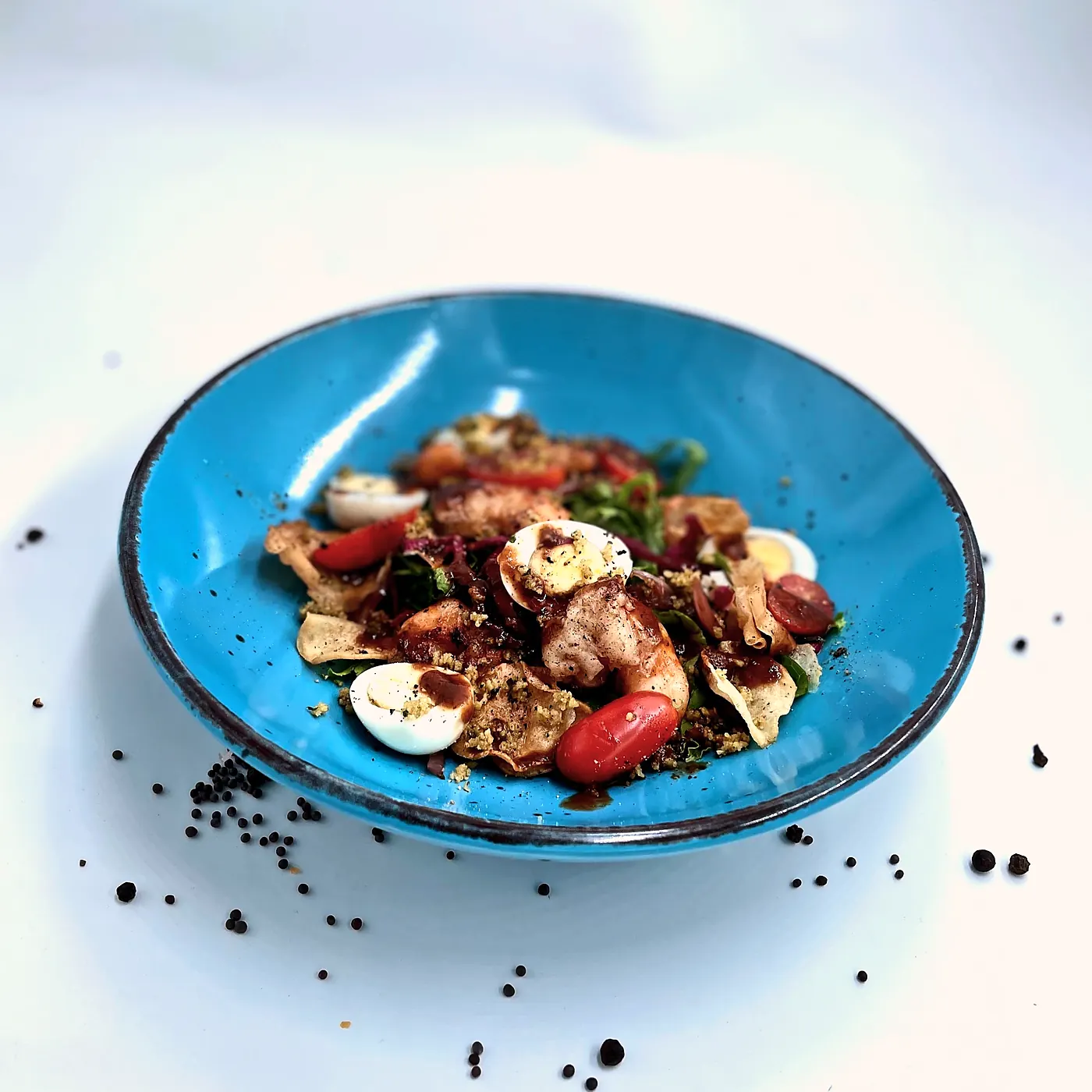Salade d'avocat, œufs de caille et tomates cerise dans une assiette bleue