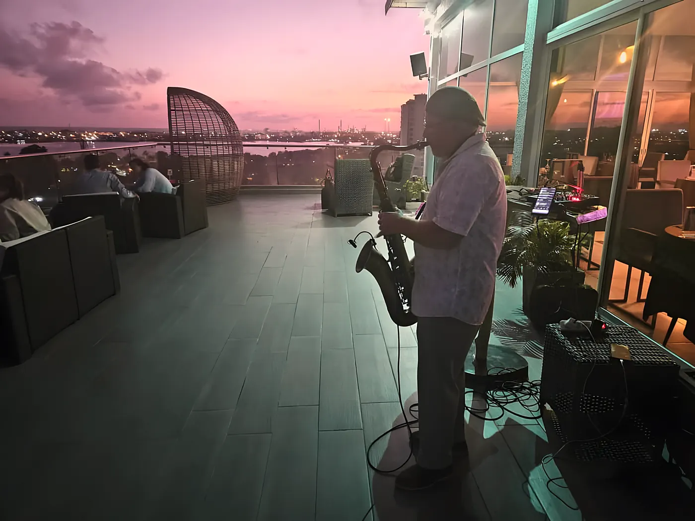 Un saxophoniste joue sur la terrasse au coucher du soleil