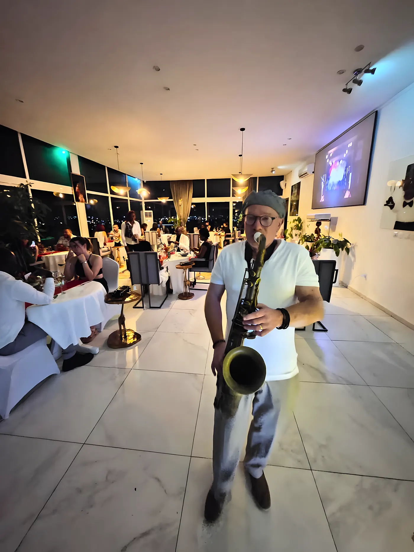 Un saxophoniste joue entre les tables de la salle