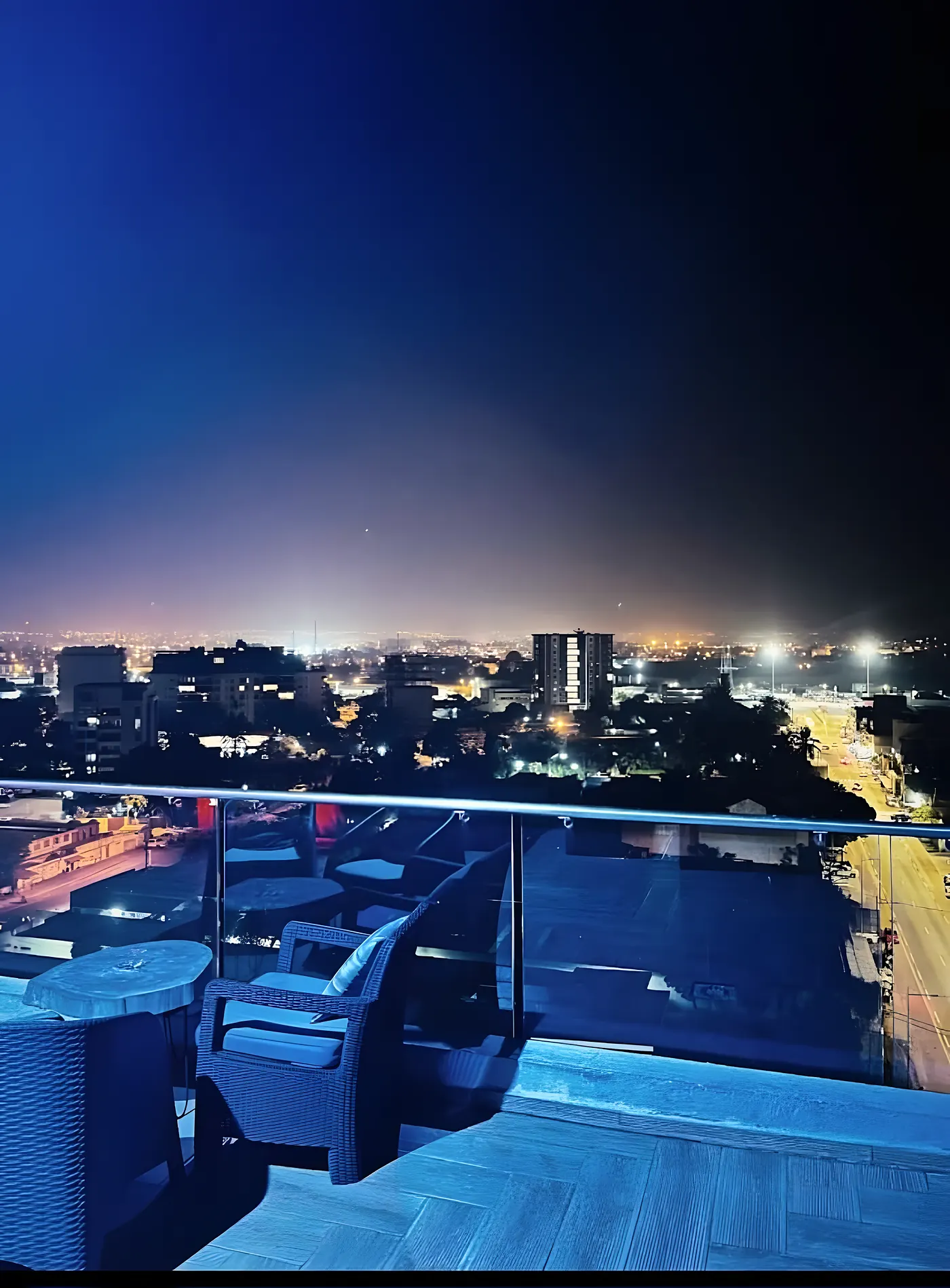 La terrasse éclairée de bleu, la ville illuminée en contrebas