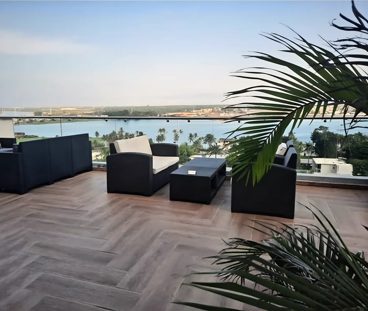La terrasse en chevrons, ses salons et les palmes, la lagune à l'horizon