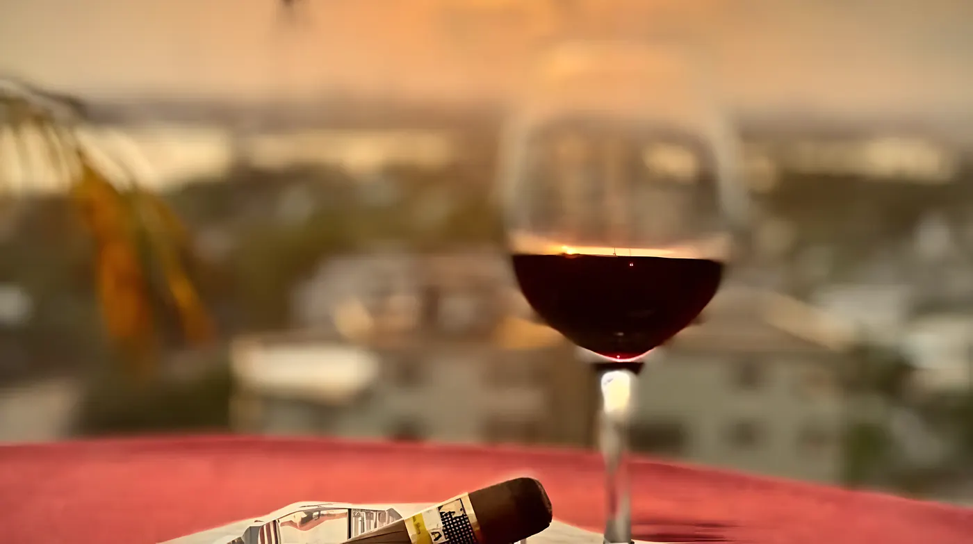 Un verre de vin rouge et un cigare au coucher du soleil, sur la terrasse